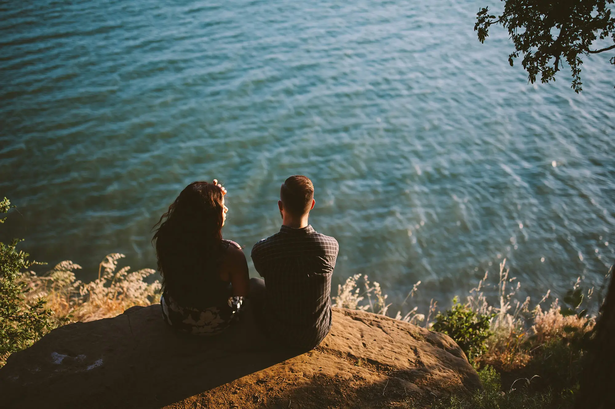 man woman sitting looking at water